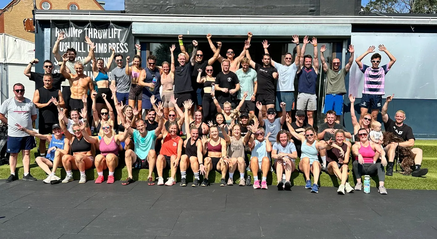 The On3 community after a class, arms raised